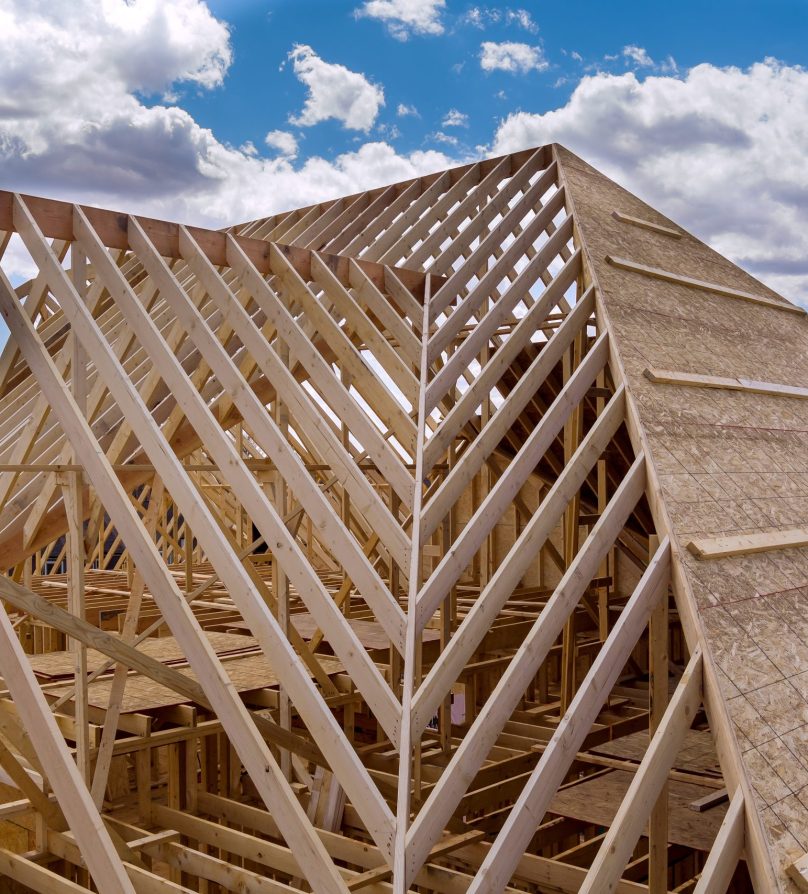 Panorama top view of closeup new wooden roof beams built home under construction under framing with construction site